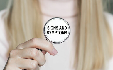 The doctor holds in his hand a stethoscope with the text SINGS AND SYMPTOMS. Medical concept