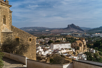 Fototapeta premium the city of Antequera. tight buildings, white houses, monuments, churches view from the castle hill. Peña de los Enamorados hills and rock in the background