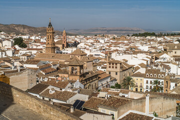 the city of Antequera. tight buildings, white houses, monuments, churches view from the castle hill. Peña de los Enamorados hills and rock in the background