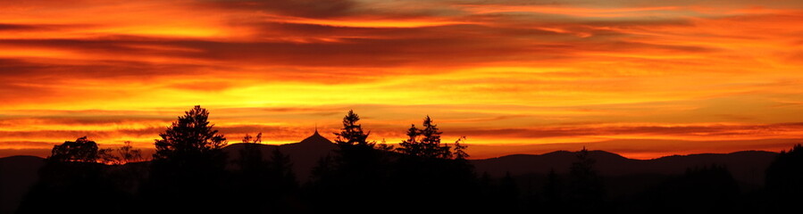 Fototapeta na wymiar orange sunset over Jizera Mountains with Ještěd mountain, background with sunset