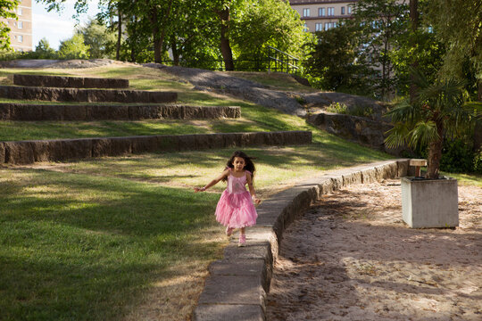 Girl in pink dress playing in park