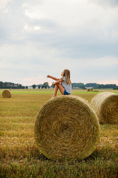 Girl sitting on hay bale
