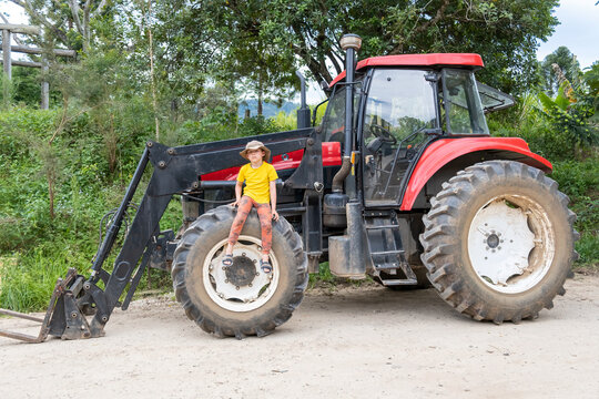 Boy sitting on a tractor wheel.