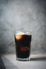 Delicious black iced coffee in tall glass, close up