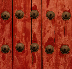 Decorative rivets on red door