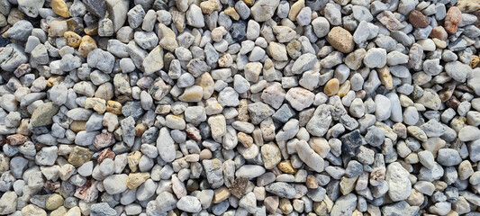 Natural gravel texture. Multi colored pebbles. Beautiful background. Vacation, holiday, beach mood.