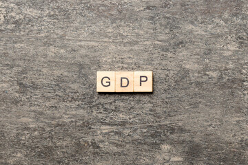 GDP word written on wood block. gross domestic product text on cement table for your desing, concept