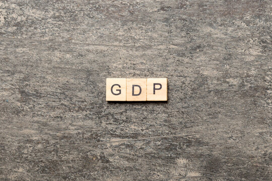 GDP word written on wood block. gross domestic product text on cement table for your desing, concept