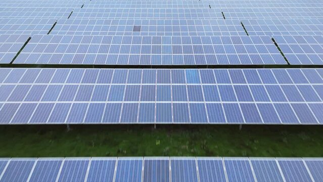 Solar panels in solar park, endless patterns, very low drone flight