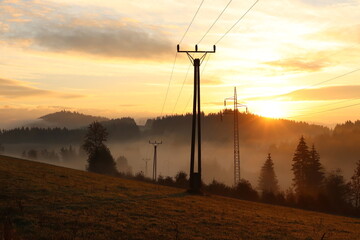 sunrise in the mountains with power lines