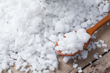 Sea salt in wooden spoon on a wood table