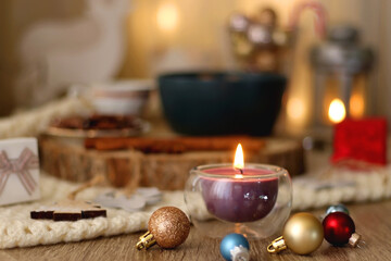 Various Christmas decorations, cup of tea or coffee, sweets, small presents, knitted blanket and candles. Selective focus.