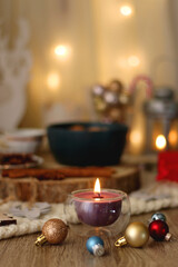 Various Christmas decorations, cup of tea or coffee, sweets, small presents, knitted blanket and candles. Selective focus.