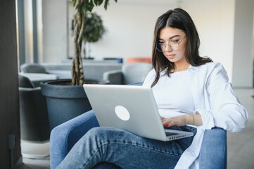 Beautiful Caucasian woman dreaming about something while sitting with portable net-book in modern cafe bar, young charming female freelancer thinking about new ideas during work on laptop computer