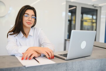 friendly young woman behind the reception desk administrator