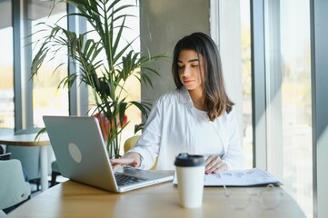 Smiling girl student study online with skype teacher, happy young woman learn language listen...