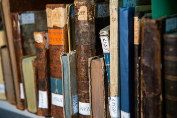 Very old books sitting on the shelves in the library. Books as a symbol of knowledge.