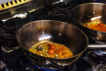 cooking pot with vegetables on the stove in the restaurant kitchen