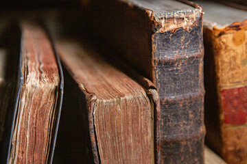 Very old books sitting on the shelves in the library. Books as a symbol of knowledge.