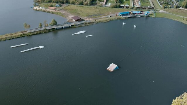 Aerial view of for jumps and tricks on wakeboarding and water skiing in a wake park on a beautiful lake