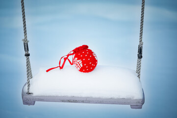 red ball on a swing against the background of snow