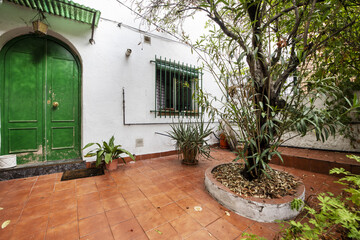 Fototapeta na wymiar A garden of a single-family house with a green gate and trees in corrals