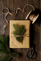 Christmas gift box with fir branches decorations on wooden background. Top view.