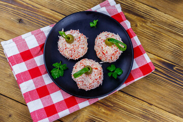 Appetizer of crab-cheese balls made in a shape of Christmas baubles on wooden table. Top view