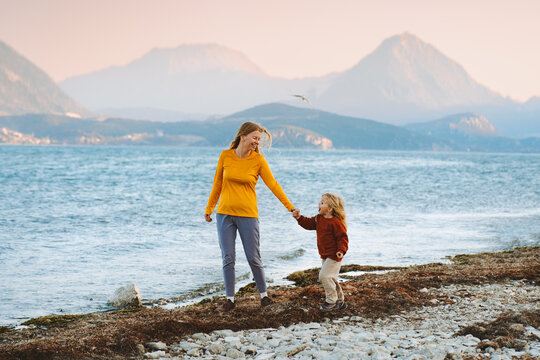 Mother and child walking outdoor family lifestyle travel together summer vacations woman parent holding hands with daughter kid at the lake Mothers day holiday