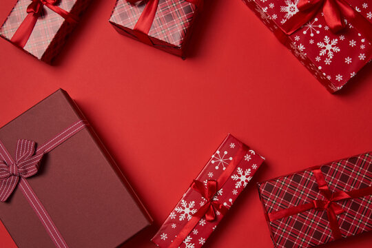 Red gift boxes with red ribbon on red background.