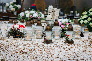 All Saints' Day and burning candles and flowers on the graves.Candles on graves symbolize the memory of the dead on November 1.Catholic cemetery during All Saints' Day.Selective focus.