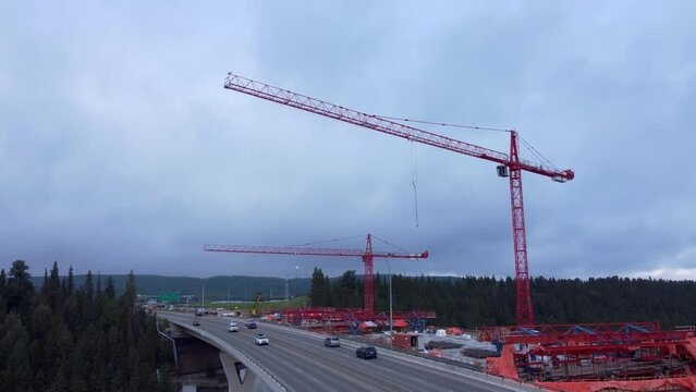 Crane by busy highway bridge construction zone