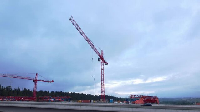 Crane by highway bridge construction zone circling