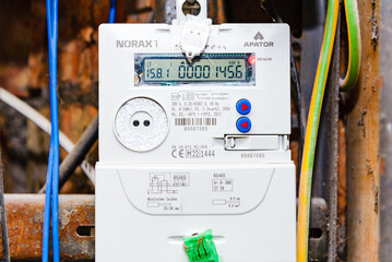 A domestic electric smart meter.Green LCD display.Concept for energy bills, price rise, inflation, cost of living and meter reading.Selective focus.Telsiai,Lithuania.03-11-2022.