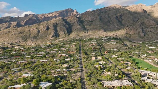 Sunny Catalina Foothills in Tucson Arizona, Drone Shot of Neighborhood, Golf Course and Mountain Range with Blue Sky in Background