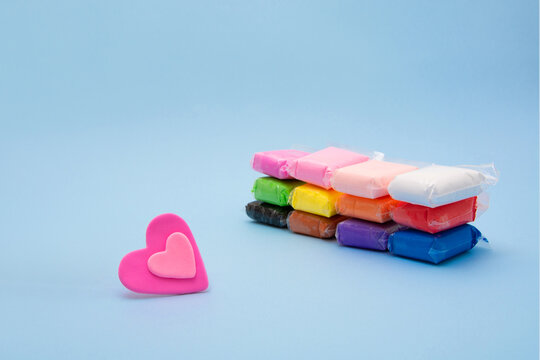 Vivid air plasticine, a soft colorful air mass for children's art that dries after modeling on pastel buel background. Modeling clay for kids education and development.