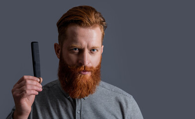 hairdresser man hold comb or hairbrush isolated on grey. hairdresser man with comb or hairbrush.