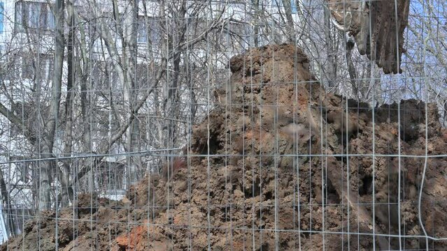 excavator digs a hole and loads the earth with a bucket, close-up