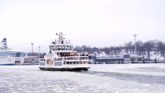 large ship, seagoing vessel Suomenlinna, ice-going ferry sails on winter along fairway laid by port icebreaker, moored off coast Helsinki, breaks ice masses, Helsinki, Finland - January 2022
