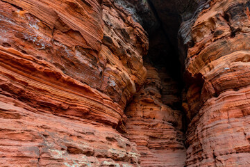 The “Altschlossfelsen“ or "Old Castle Rocks" is a colorful red rock outcrop formed of bunter sandstone in the Palatine Forest of Germany on autumn day. Popular hiking spot with dark cave passage.