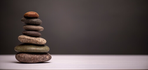stacked stones against a grey background with copy space