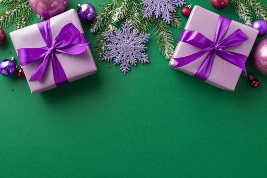 Christmas mood concept. Top view photo of lilac gift boxes with violet bows pink purple baubles snowflake ornaments pine branches in snow and sequins on isolated green background with blank space