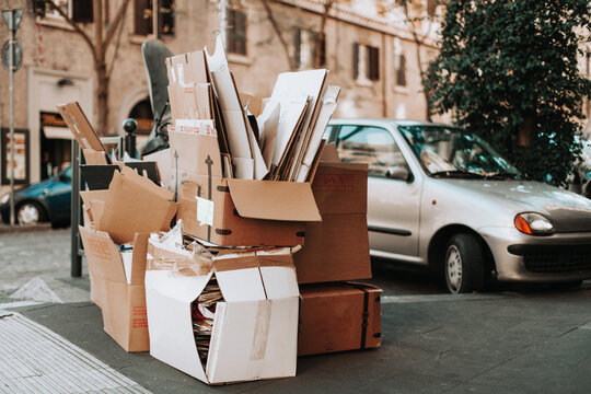 cardboard boxes are stacked on the street for recycling.