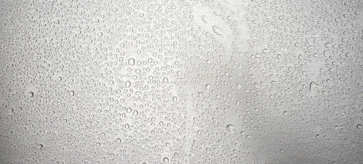 Photo of the texture of a chrome-plated iron surface in raindrops. Precipitation on the metal surface. Wet background of silver color.