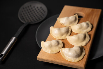 freshly prepared dumplings with kitchen utensils