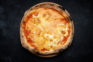 Pizza with cheese and tomatoes on a dark background