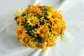 Bouquet of bright sunny yellow flowers on a light pastel background	