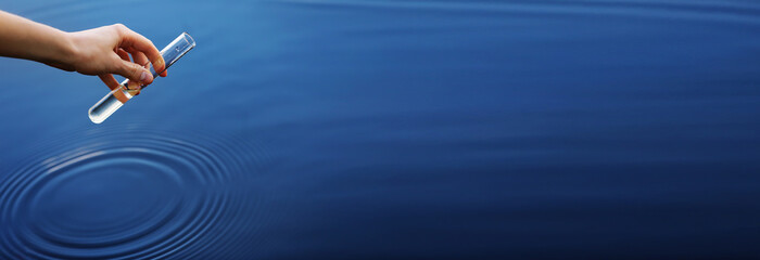 banner water sample. Hand collects water to explore. Concept - water purity analysis, environment,...