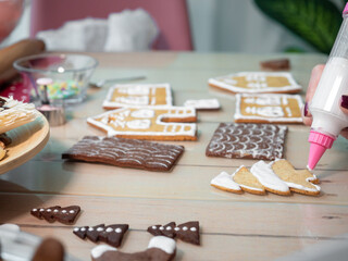 Decorating christmas gingerbread cookies with white glaze 