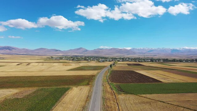  Aerial footage road between lake and field. Road near Sevan lake in Armenia, Caucasus. Highway traffic near water.   Most popular lake in Armenia, western Asia.